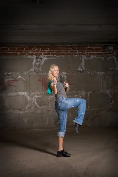 Beautiful hip hop girl dancing over grey brick wall — Stock Photo, Image