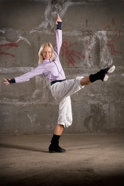 Hermosa chica de hip hop bailando sobre la pared de ladrillo gris —  Fotos de Stock