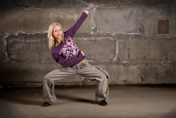 Schönes Hip-Hop-Mädchen tanzt über graue Ziegelwand — Stockfoto