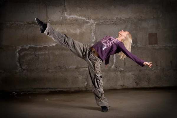 Menina hip hop bonita dançando sobre parede de tijolo cinza — Fotografia de Stock