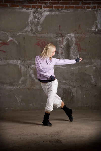 Menina hip hop bonita dançando sobre parede de tijolo cinza — Fotografia de Stock