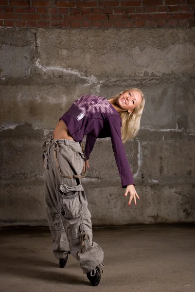 Belle fille hip hop dansant sur un mur de briques grises — Photo