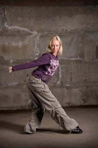 Hermosa chica de hip hop bailando sobre la pared de ladrillo gris — Foto de Stock