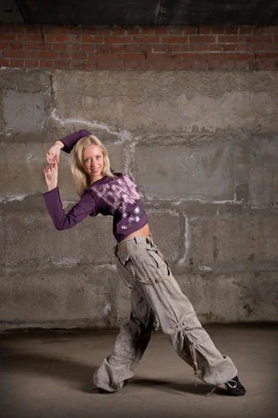 Bella ragazza hip hop che balla sul muro di mattoni grigi — Foto Stock
