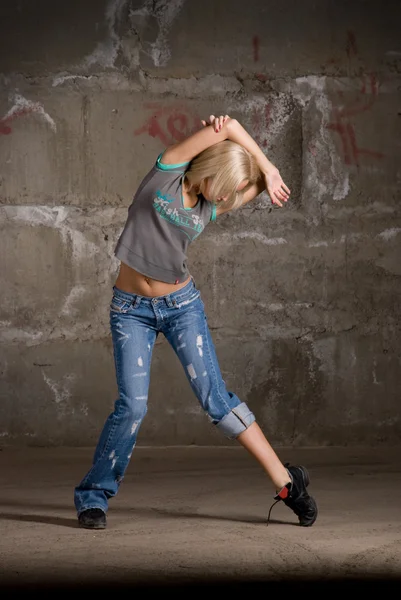 Красива дівчина хіп-хоп танцює над сірою цегляною стіною — стокове фото