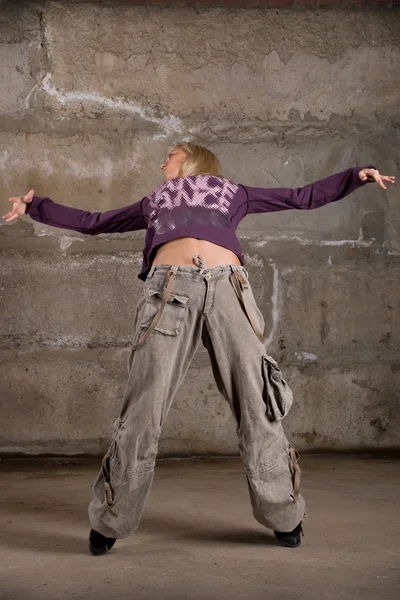 Όμορφη χιπ χοπ κορίτσι χορό πάνω από το τοίχο από τούβλα γκρι — Φωτογραφία Αρχείου
