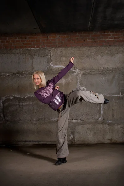 Красива дівчина хіп-хоп танцює над сірою цегляною стіною — стокове фото