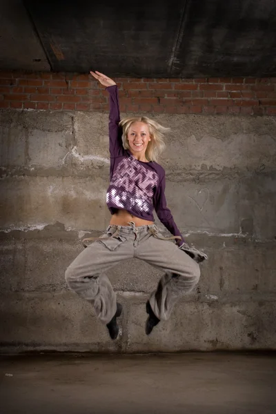 Belle fille hip hop dansant sur un mur de briques grises — Photo
