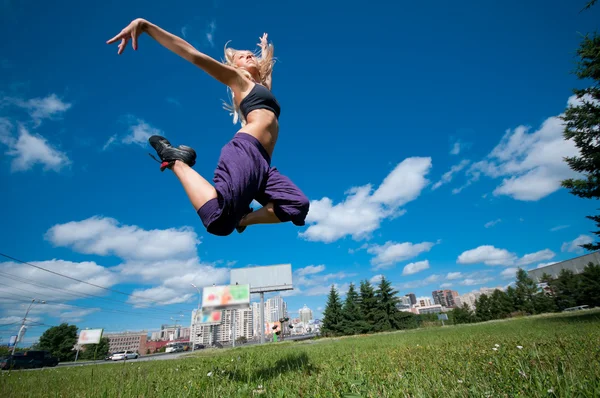 Mulher dançando sobre a rua verde da cidade — Fotografia de Stock