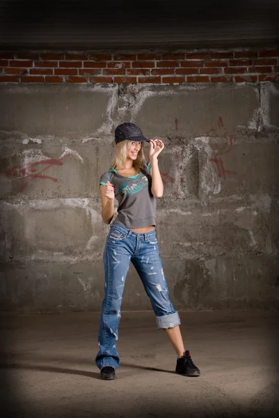 Mooie hip hop meisje dansen over grijze bakstenen muur — Stockfoto