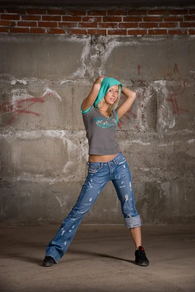 Красивая хип-хоп девушка танцует над серой кирпичной стеной — стоковое фото