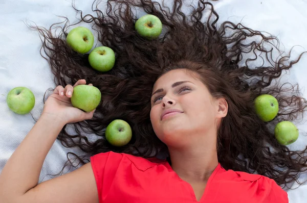 Woman lying in wheat field with green apple. Picnic. — Stock Photo, Image