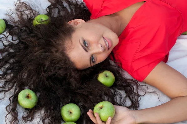 Vrouw liggen in tarweveld met groene appel. picknick. — Stockfoto