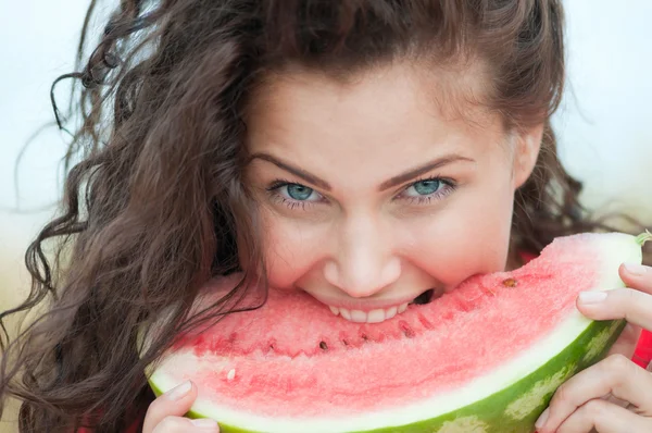 Vrouw in een tarweveld eten watermeloen. picknick. — Stockfoto