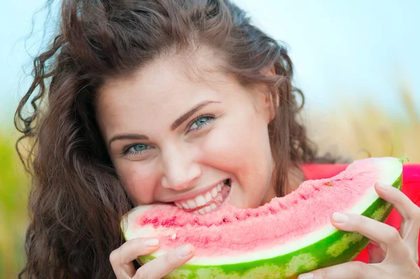 Žena v pšeničné pole jíst meloun. piknik. — Stock fotografie