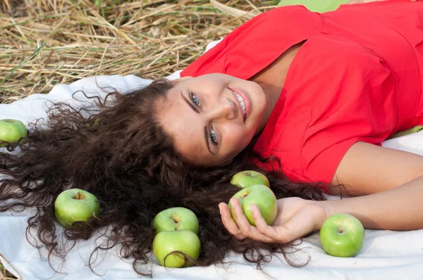 Frau liegt im Weizenfeld mit grünem Apfel. Picknick. — Stockfoto