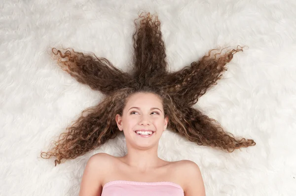 Lány a tökéletes göndör haj, prém ágyon — Stock Fotó