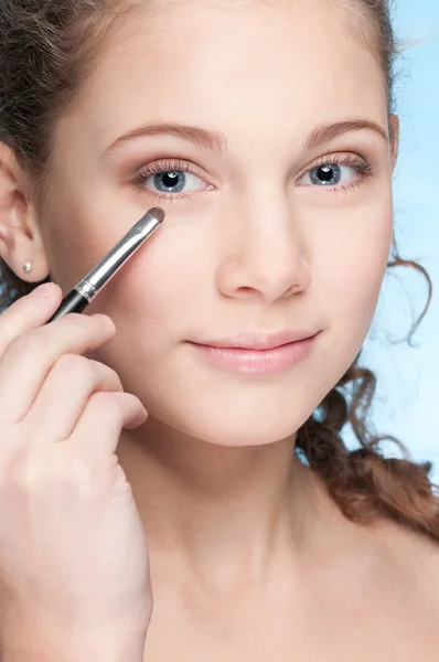 Krásná mladá dívka dělá make-up pomocí štětce — Stock fotografie
