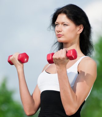 kadın dumbbell ile egzersiz yaparak