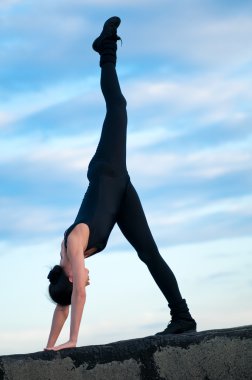 Mavi gökyüzü üzerinde dans eden bir kadın. Yoga