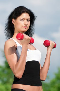 kadın dumbbell ile egzersiz yaparak