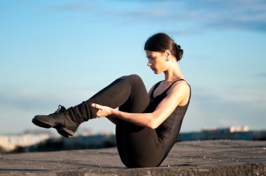 Mavi gökyüzü üzerinde dans eden bir kadın. Yoga