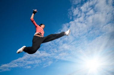 Spor kadın Jumping ve gökyüzü ve güneş üzerinde sinek
