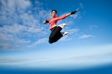 Spor kadın Jumping ve gökyüzü üzerinde sinek