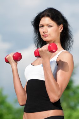 kadın dumbbell ile egzersiz yaparak