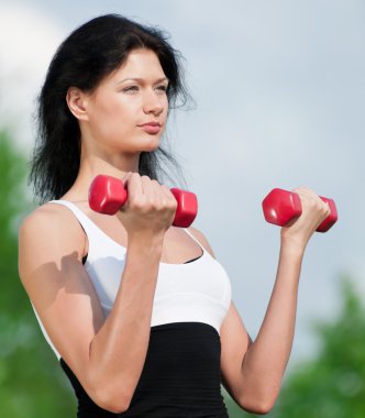 kadın dumbbell ile egzersiz yaparak