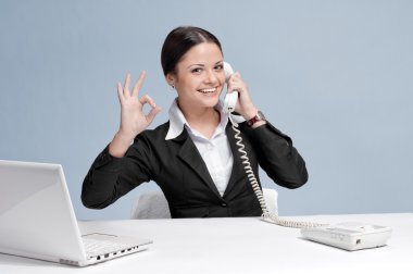 Casual business woman in office talking by phone clipart