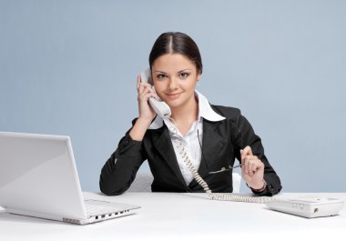 Casual business woman in office talking by phone clipart