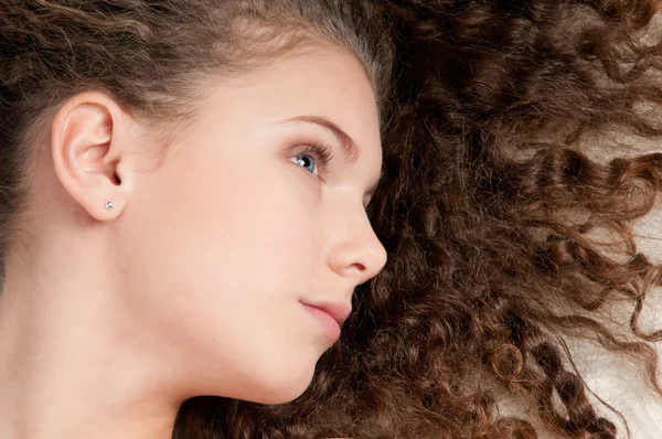 Mädchen mit perfektem lockigem Haar liegt auf Fellbett — Stockfoto