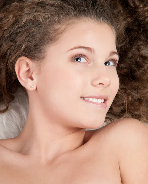 Lány a tökéletes göndör haj, prém ágyon — Stock Fotó