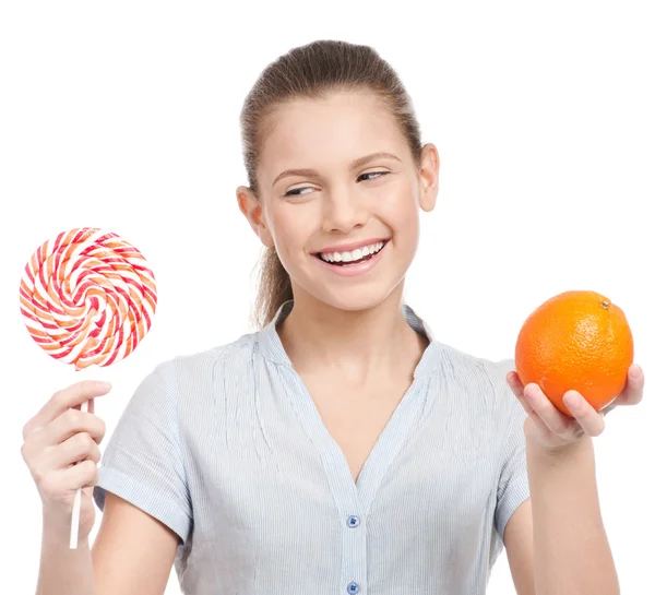 Ganska ung kvinna med lollipop och orange. Val — Stockfoto