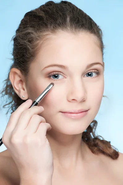 Mooi meisje doen make-up door borstel — Stockfoto