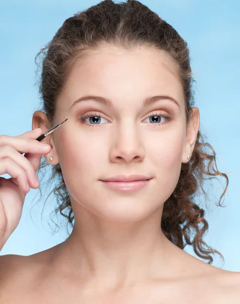 Mooi meisje doen make-up door borstel — Stockfoto