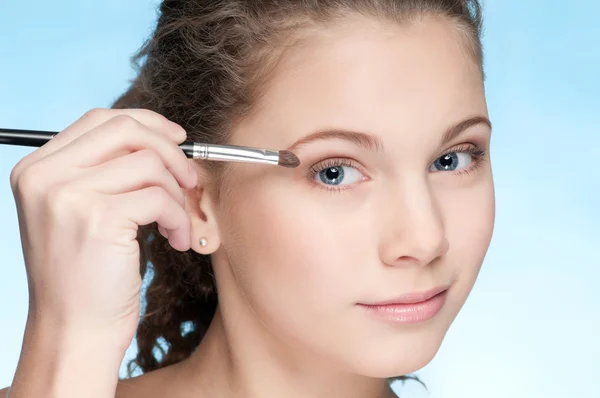 Young beautiful girl doing make-up by brush — Stock Photo, Image