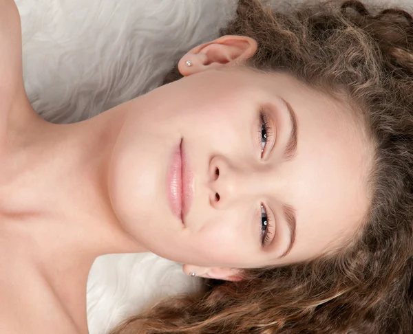 Kürk yatakta yatarken mükemmel kıvırcık saçlı kız — Stok fotoğraf