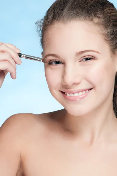 Young beautiful girl doing make-up by brush — Stock Photo, Image