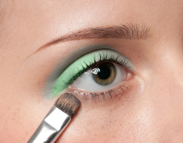 Mujer aplicando pincel cosmético en la zona del ojo — Foto de Stock