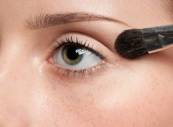 Žena použití kosmetický štětec na oční zóny — Stock fotografie