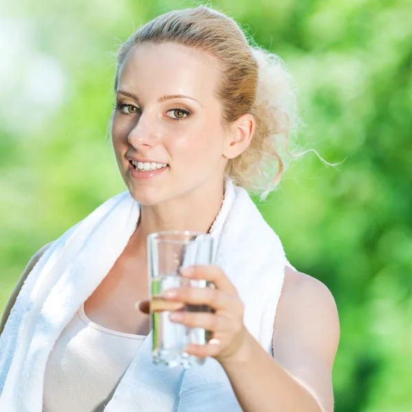 Nainen juomavesi liikunnan jälkeen — kuvapankkivalokuva