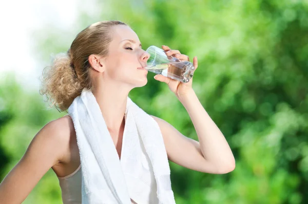 Mujer bebiendo agua después del ejercicio — Foto de Stock