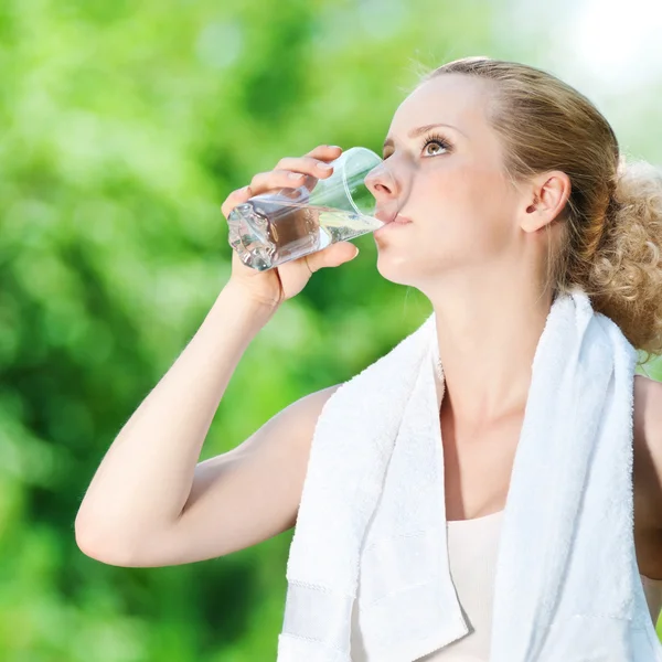 Жінка п'є воду після вправ — стокове фото