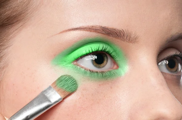Mulher aplicando pincel de tinta cosmética na zona dos olhos — Fotografia de Stock