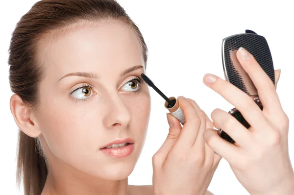 Beautiful woman applying mascara on her eyelashes — Stock Photo, Image