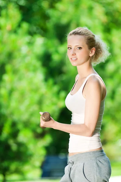Woman doing dumbbell exercise outdoor — Stock Photo, Image