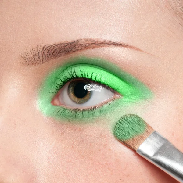 Mulher aplicando pincel de tinta cosmética na zona dos olhos — Fotografia de Stock