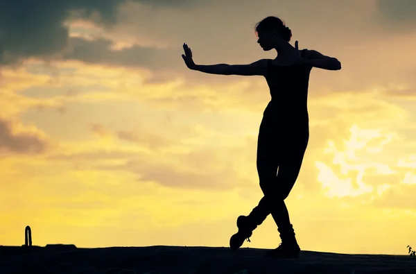 Siluett av dansande kvinna över solnedgången. Yoga — Stockfoto
